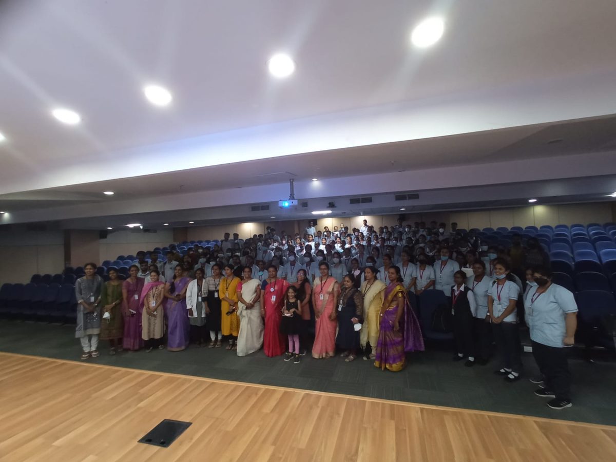 Group photo on stage with a full auditorium