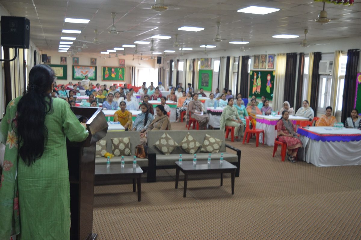Dr. Kaushal addressing a seated audience in a hall